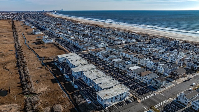 drone / aerial view featuring a water view and a view of the beach