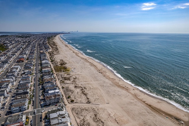 drone / aerial view featuring a water view and a view of the beach