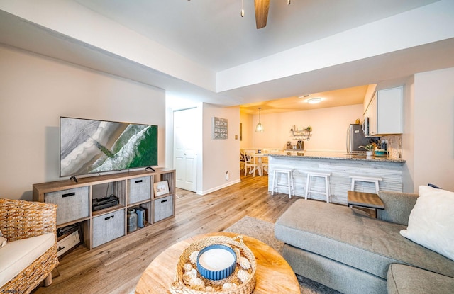 living room with ceiling fan and light hardwood / wood-style floors