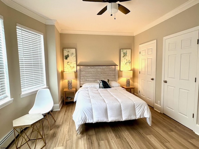 bedroom featuring wood-type flooring, crown molding, and baseboard heating