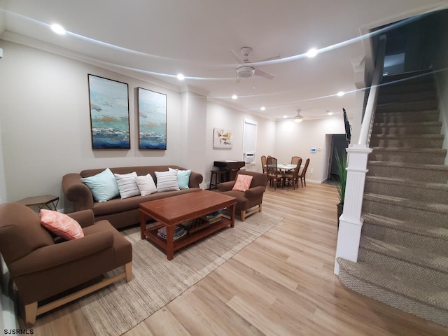 living room with ceiling fan, ornamental molding, and light hardwood / wood-style floors