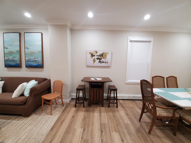 dining room with ornamental molding, a baseboard heating unit, and light wood-type flooring