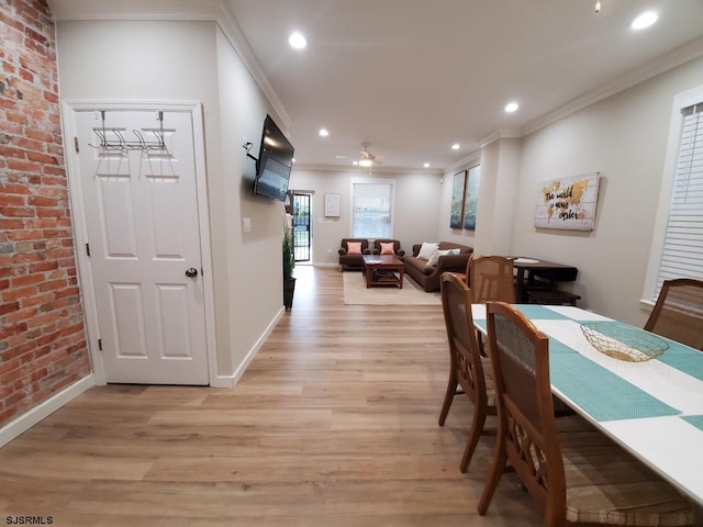 dining space featuring crown molding, brick wall, ceiling fan, and light hardwood / wood-style flooring