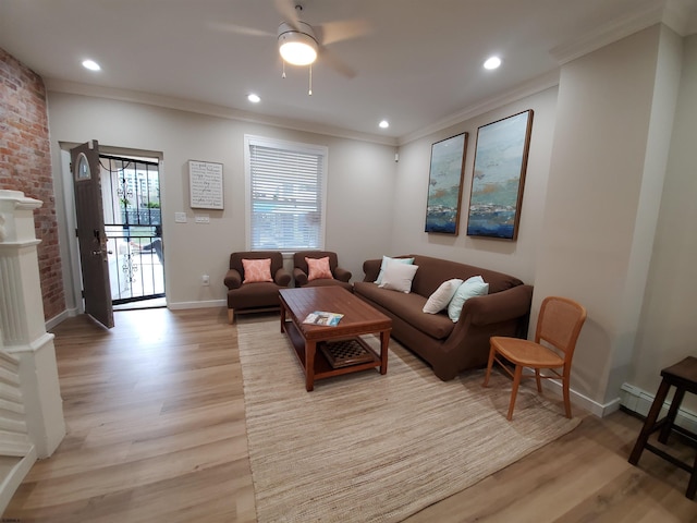 living room with crown molding, ceiling fan, light hardwood / wood-style floors, and a brick fireplace