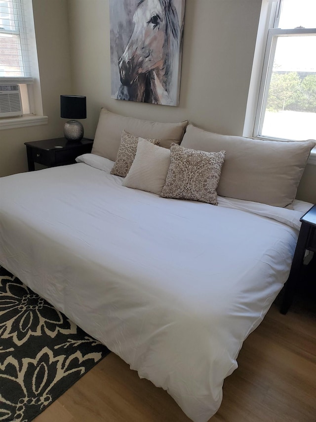 bedroom with hardwood / wood-style flooring and cooling unit