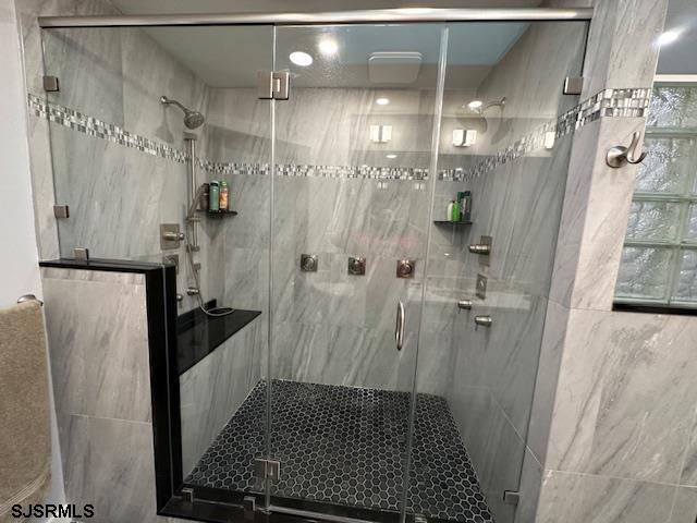 bathroom featuring a shower with door