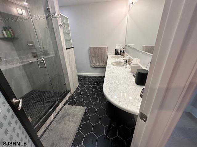 bathroom featuring sink, tile patterned floors, and a shower with shower door