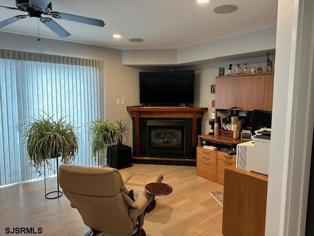 living room with ceiling fan and light hardwood / wood-style flooring