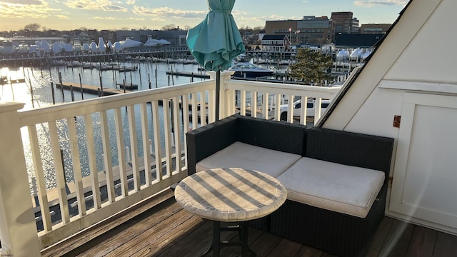 balcony at dusk featuring a water view