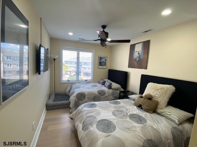 bedroom with ceiling fan and light wood-type flooring