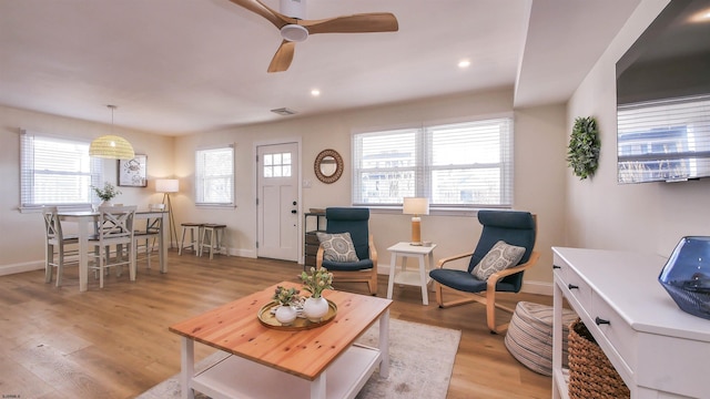 living room featuring ceiling fan and light hardwood / wood-style floors