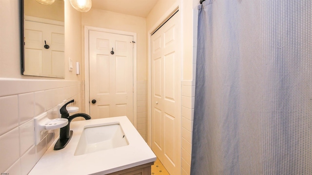 bathroom with vanity and tile walls