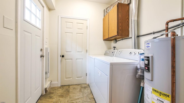 laundry area with cabinets, electric water heater, and washing machine and clothes dryer