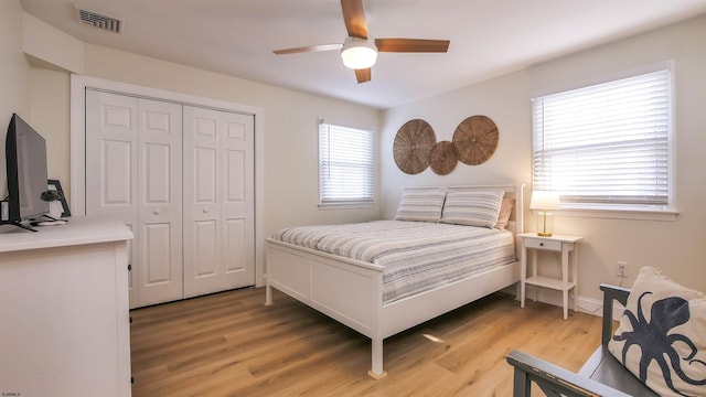 bedroom with hardwood / wood-style floors, a closet, and ceiling fan