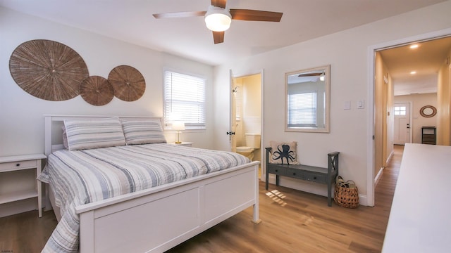 bedroom with multiple windows, wood-type flooring, ceiling fan, and ensuite bath