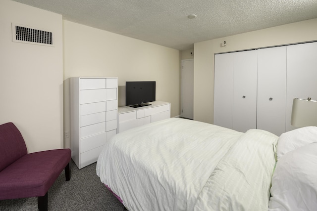 bedroom featuring a closet, a textured ceiling, and carpet