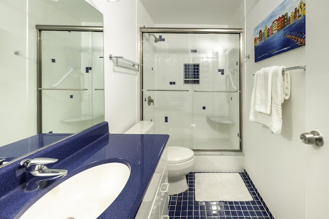 bathroom featuring tile patterned floors, toilet, a shower with shower door, and vanity