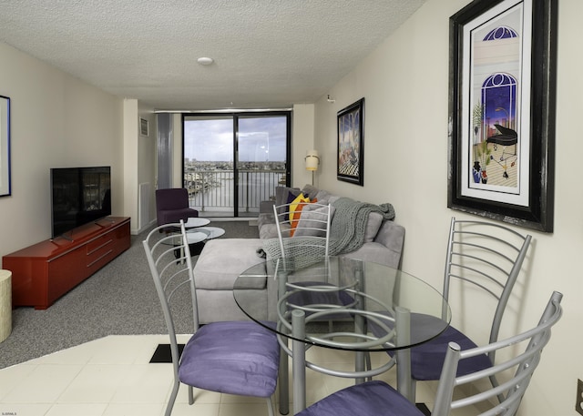 living room featuring light carpet, a textured ceiling, and a wall of windows