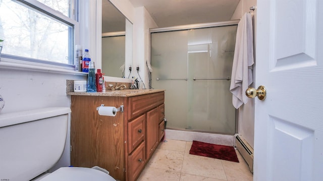 bathroom with baseboard heating, tile patterned flooring, vanity, a shower with shower door, and toilet