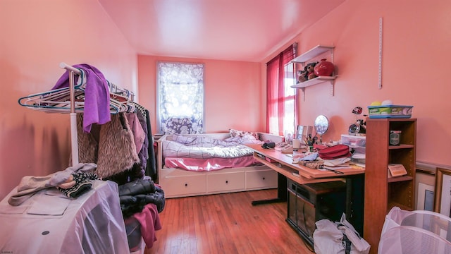 bedroom with multiple windows and hardwood / wood-style flooring