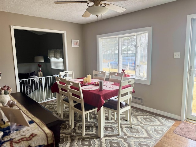 dining area with wood-type flooring, ceiling fan, and a textured ceiling