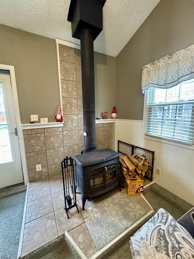 interior details with a textured ceiling and a wood stove