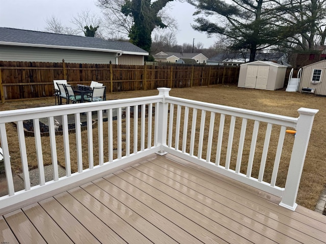 wooden deck featuring a shed and a lawn