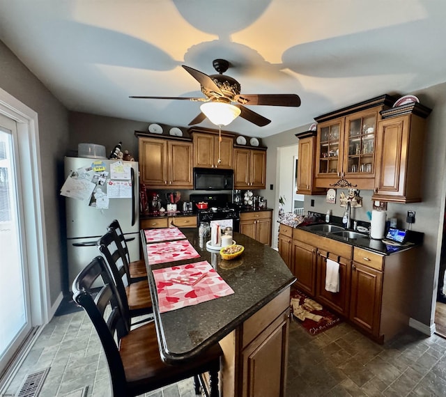 kitchen featuring sink, black appliances, ceiling fan, and a kitchen island