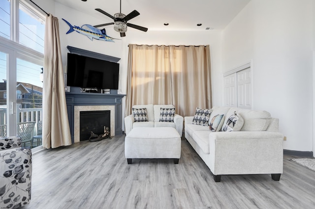 living room featuring ceiling fan, plenty of natural light, and light hardwood / wood-style flooring