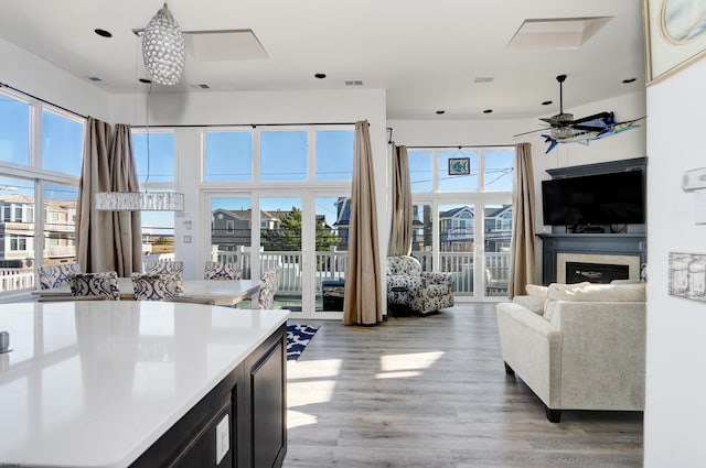 living room featuring hardwood / wood-style flooring, ceiling fan, plenty of natural light, and a high ceiling