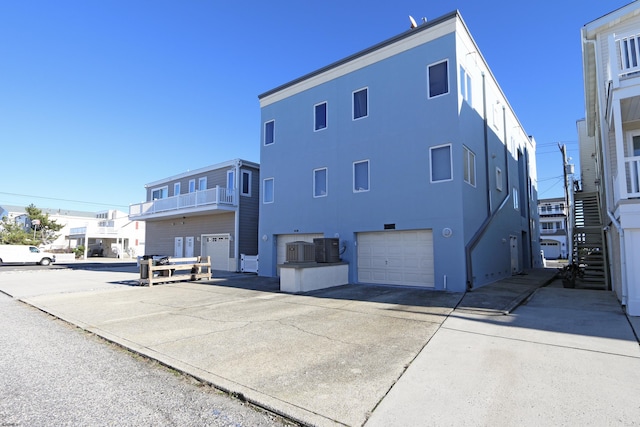 back of property featuring a garage and central AC unit