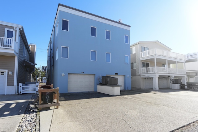 view of property exterior with a garage and central AC unit