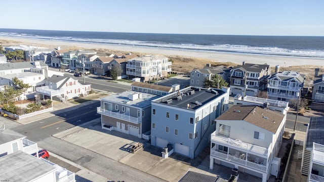 birds eye view of property with a water view and a beach view