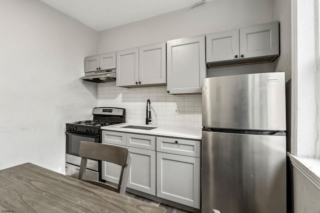 kitchen with tasteful backsplash, appliances with stainless steel finishes, sink, and gray cabinets