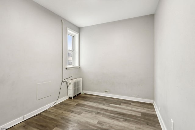 unfurnished room with wood-type flooring and radiator heating unit