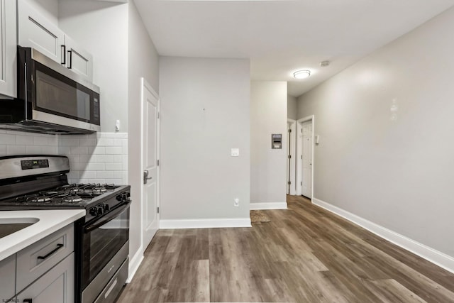 kitchen featuring tasteful backsplash, stainless steel appliances, and hardwood / wood-style floors