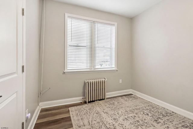 spare room with dark wood-type flooring and radiator heating unit