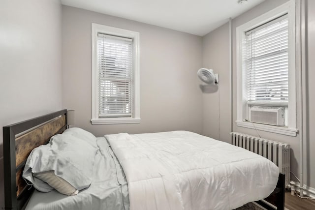 bedroom with radiator heating unit and hardwood / wood-style floors