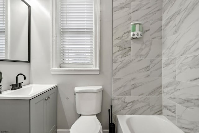 full bathroom with vanity, tiled shower / bath combo, and toilet