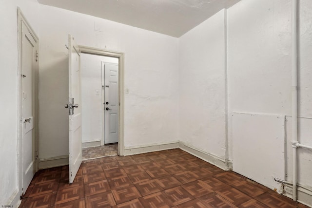 unfurnished room featuring dark parquet flooring