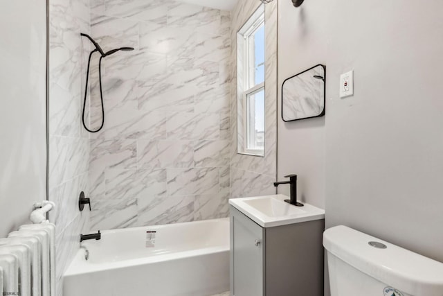 full bathroom featuring tiled shower / bath, vanity, toilet, and radiator