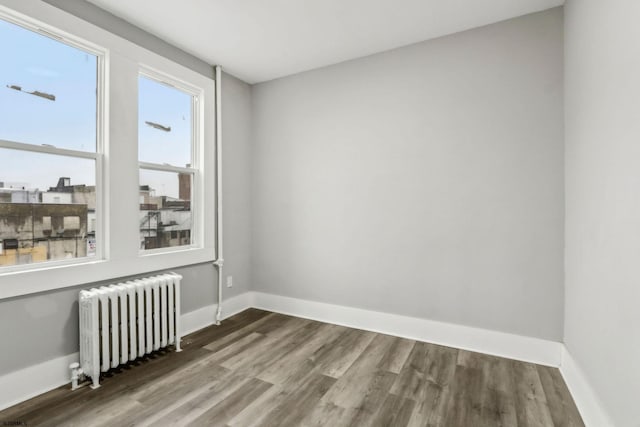 spare room with radiator and hardwood / wood-style floors