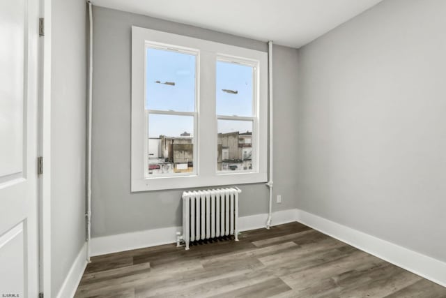 unfurnished room with hardwood / wood-style flooring and radiator