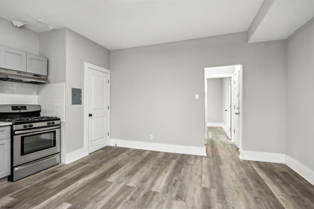 kitchen featuring tasteful backsplash, gray cabinets, light wood-type flooring, and stainless steel gas stove