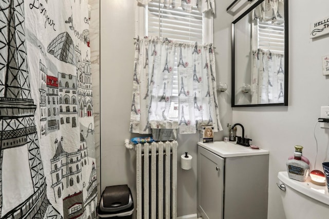 bathroom featuring vanity, radiator, and toilet