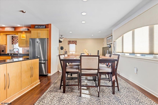 dining room with ceiling fan, sink, and dark hardwood / wood-style flooring