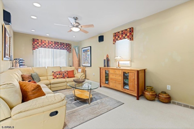 carpeted living room with ceiling fan and plenty of natural light