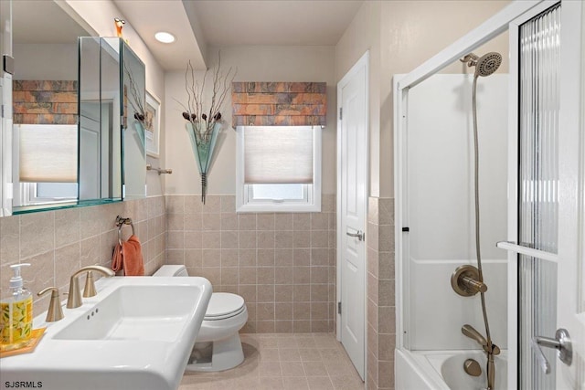 full bathroom featuring sink, washtub / shower combination, tile walls, tile patterned floors, and toilet