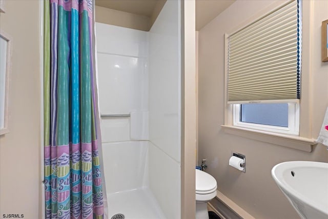 bathroom with sink, curtained shower, and toilet