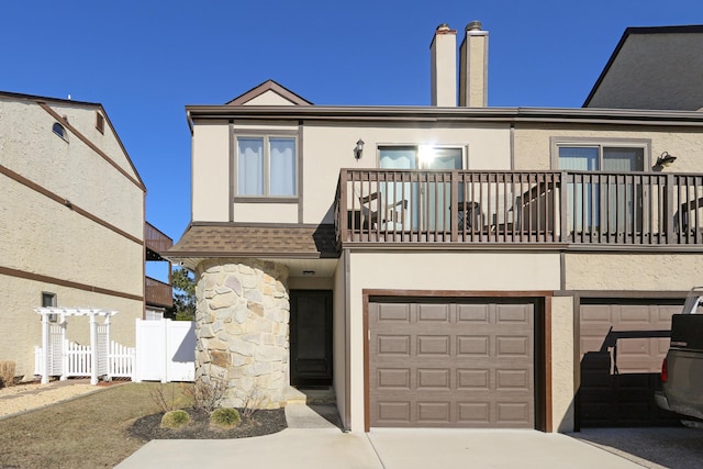 townhome / multi-family property featuring a balcony and a garage